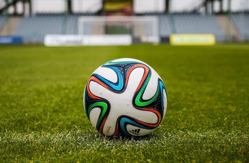 Ballon de football posé sur un terrain en herbe 